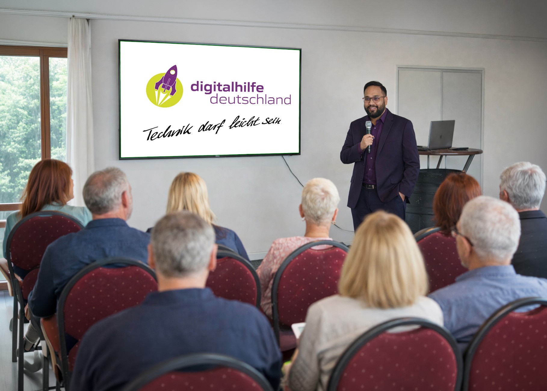 Senioren lernen mit Unterstützung den Umgang mit Laptop